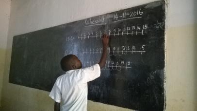 A pupil working on the numberline challenge on the chalkboard